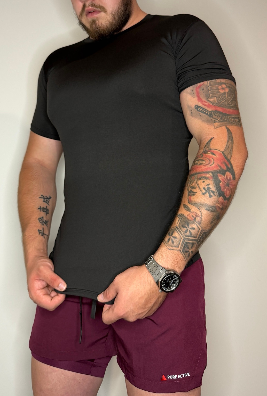 Black fitted tee worn with burgundy Pure Active shorts